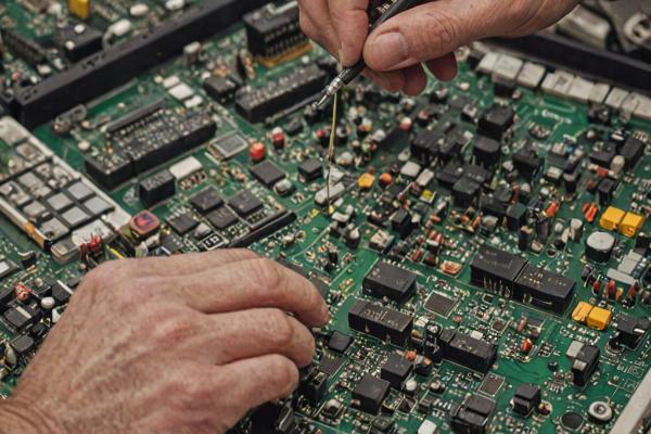 Skilled technician performing TV electronics repair
